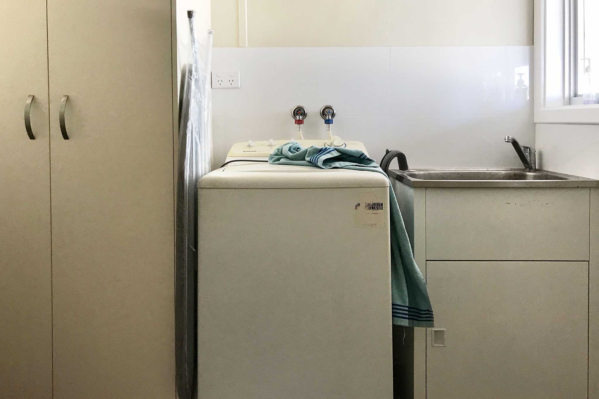 The laundry is equipped with a top-loading washing machine and a full-sized laundry trough. Cleaning materials are supplied. The toilet is situated off the laundry.